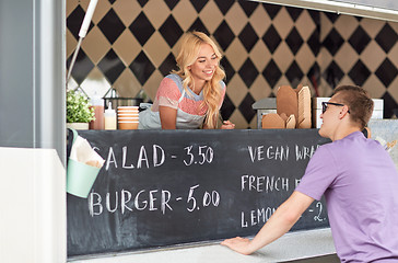 Image showing saleswoman at food truck serving male customer