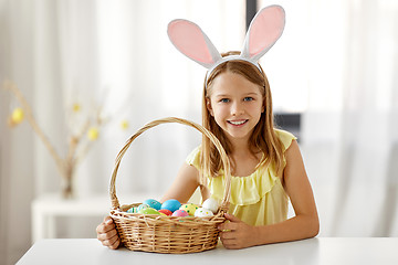 Image showing happy girl with colored easter eggs at home