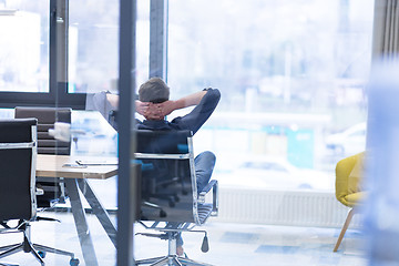 Image showing young businessman relaxing at the desk