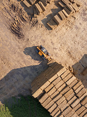 Image showing The loader stacks bales of straw into the stack after harvesting the grain. Top view.