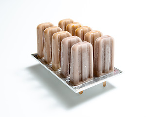 Image showing Coffee ice cream. Plastic molds with homemade ice cream on a sti