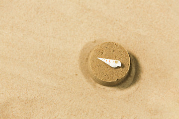 Image showing sand shape made by mold with shell on summer beach