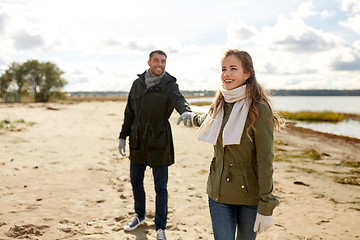 Image showing couple walking along autumn beach