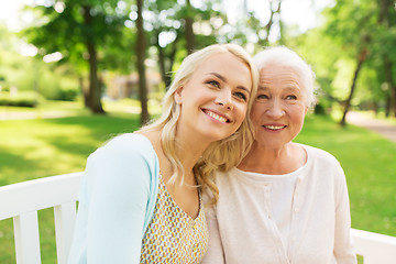 Image showing daughter with senior mother sitting on park bench