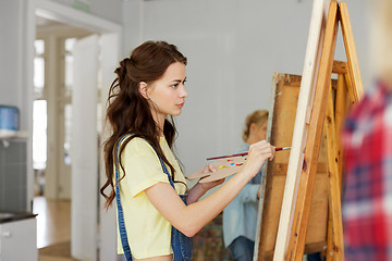 Image showing woman with easel painting at art school studio