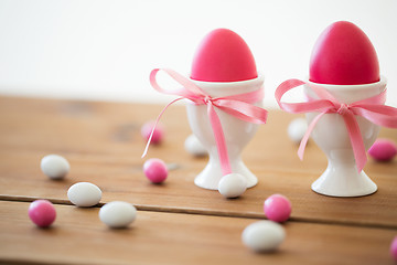 Image showing easter eggs in holders and candy drops on table