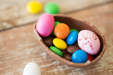 Image showing chocolate easter egg and candy drops on table