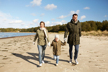 Image showing happy family walking along autumn beach