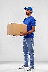 Image showing happy indian delivery man with parcel box in blue