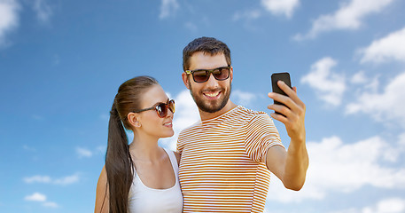 Image showing happy couple taking selfie by smartphone in summer