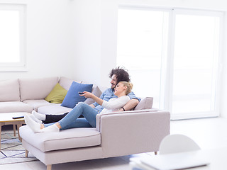 Image showing Young couple on the sofa watching television