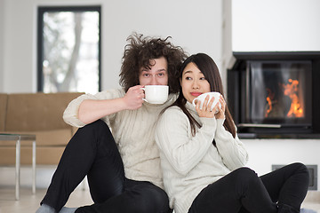 Image showing happy multiethnic couple  in front of fireplace