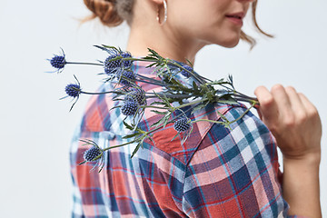 Image showing Young girl with flowers eryngium