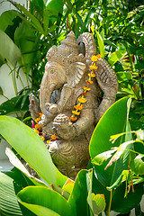 Image showing Garland of golden flowers draped around Ganesha
