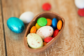 Image showing chocolate easter egg and candy drops on table