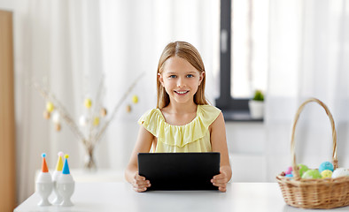 Image showing happy girl with tablet pc and easter eggs at home