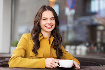 Image showing teenage girl drinking hot chocolate at city cafe