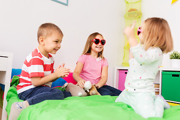 Image showing happy little kids in sunglasses playing at home