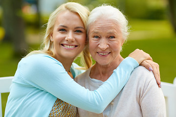 Image showing daughter with senior mother hugging on park bench