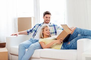 Image showing happy couple opening parcel box at home