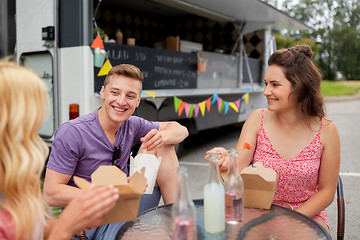 Image showing happy friends with drinks eating at food truck