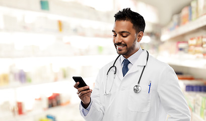 Image showing smiling indian male doctor with smartphone