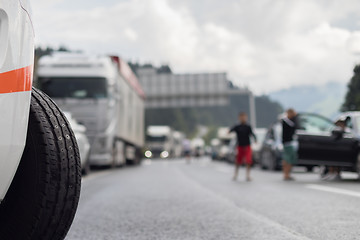 Image showing Typical scene on European highways during summer holiadays rush hour. A traffic jam with rows of cars tue to highway car accident. Empty emergency lane. Shallow depth of field