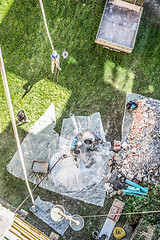 Image showing Top view of authentic builder men working with shovel during concrete cement solution mortar preparation in mixer at construction site