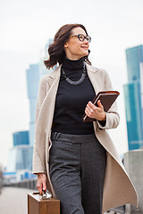 Image showing Lucky beautiful business woman in a light coat