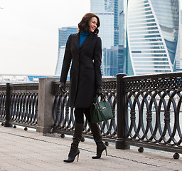 Image showing Beautiful middle-aged woman in a dark coat and with a green hand