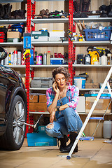 Image showing woman in blue denim overall talking on the smartphone near the c