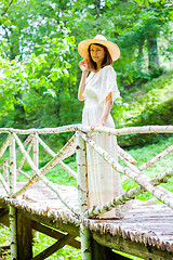 Image showing beautiful middle-aged woman in a white summer dress and hat