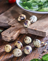 Image showing Quail eggs and greens in a plate on a wooden table. Ingredients for Making Healthy Salad