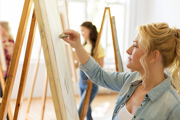 Image showing woman with easel drawing at art school studio