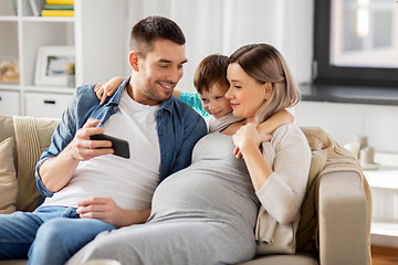 Image showing happy family with smartphone at home