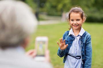 Image showing little girl being photographed at summer park