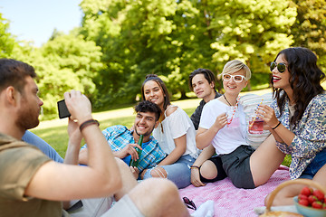Image showing guy taking picture of friends on summer picnic