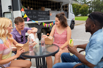 Image showing happy friends with drinks eating at food truck