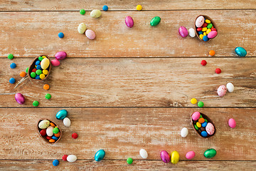 Image showing chocolate eggs and candy drops on wooden table