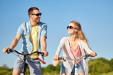 Image showing happy young couple riding bicycles in summer