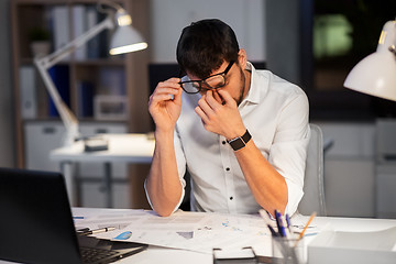 Image showing tired businessman working at night office