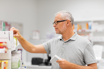 Image showing senior male customer with drug at pharmacy