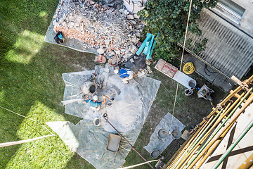 Image showing Top view of authentic builder men working with shovel during concrete cement solution mortar preparation in mixer at construction site