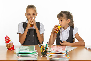 Image showing Two school friends drink juice at a table in a school class