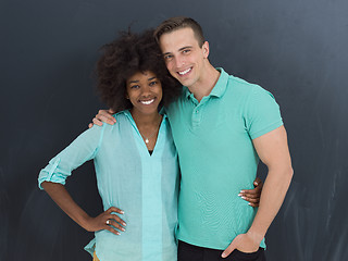 Image showing multiethnic couple in front of gray chalkboard