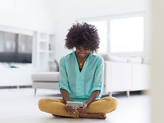 Image showing black women using tablet computer on the floor at home