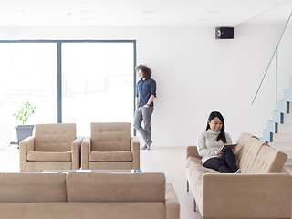 Image showing multiethnic couple at home using tablet computers