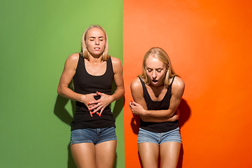 Image showing Young women overwhelmed with a pain in the stomach .