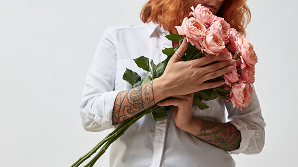 Image showing the girl is holding a bouquet of pink roses