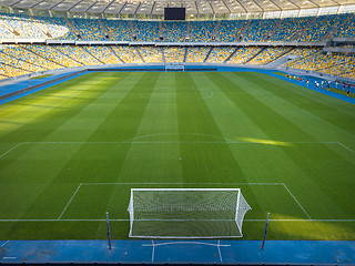 Image showing KYIV, UKRAINE - July 19, 2018. Perspective view of NSC Olimpiysky - the inside part with a green football field, tribunes and treadmills.